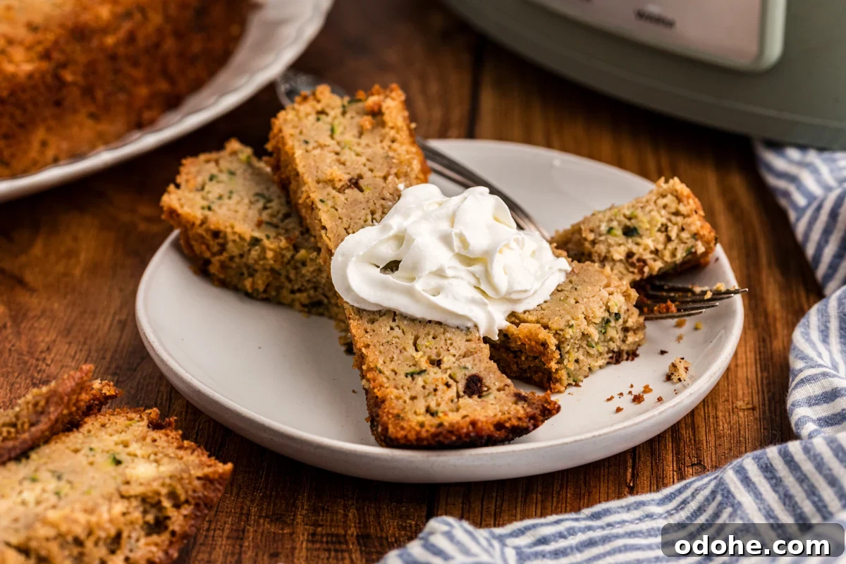 zucchini bread slices on a plate with whipped cream.