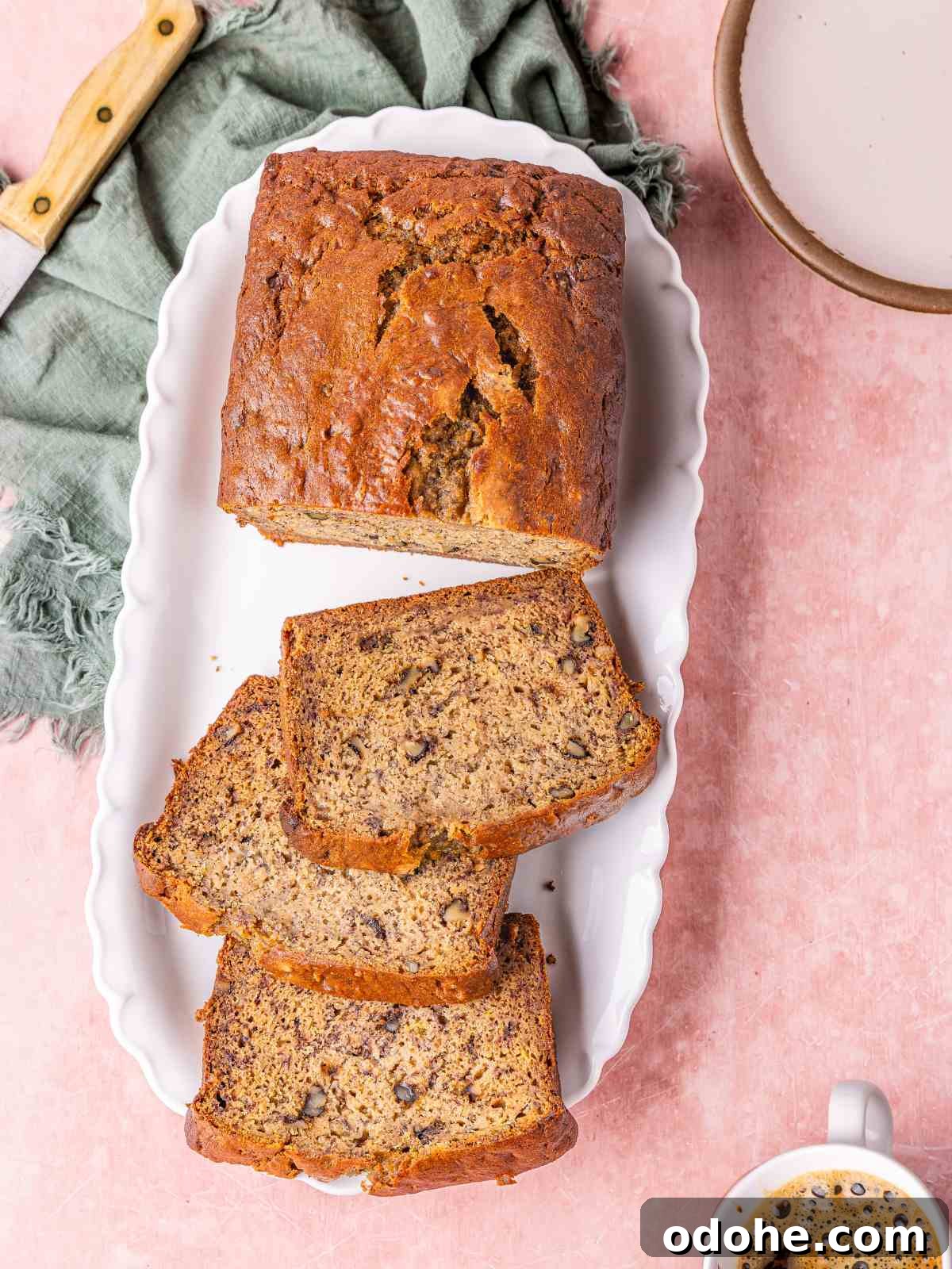 High protein banana nut bread on a white plate with coffee on the side.