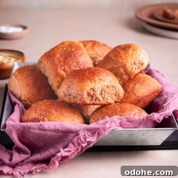 banana yeast bread roll served on a pan with kitchen towel, and a bowl of butter.