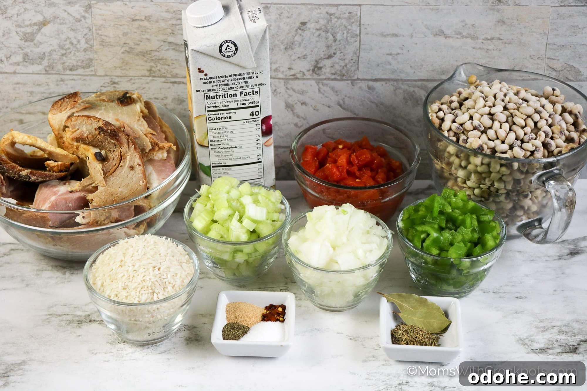 Slow Cooker Hoppin' John Recipe — Classic Southern Black-Eyed Peas 3 Ham, black eyed peas, onion, and other ingredients in clear glass bowls on counter