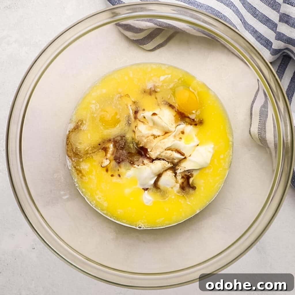 Eggs, sour cream, melted butter, and vanilla in a bowl.