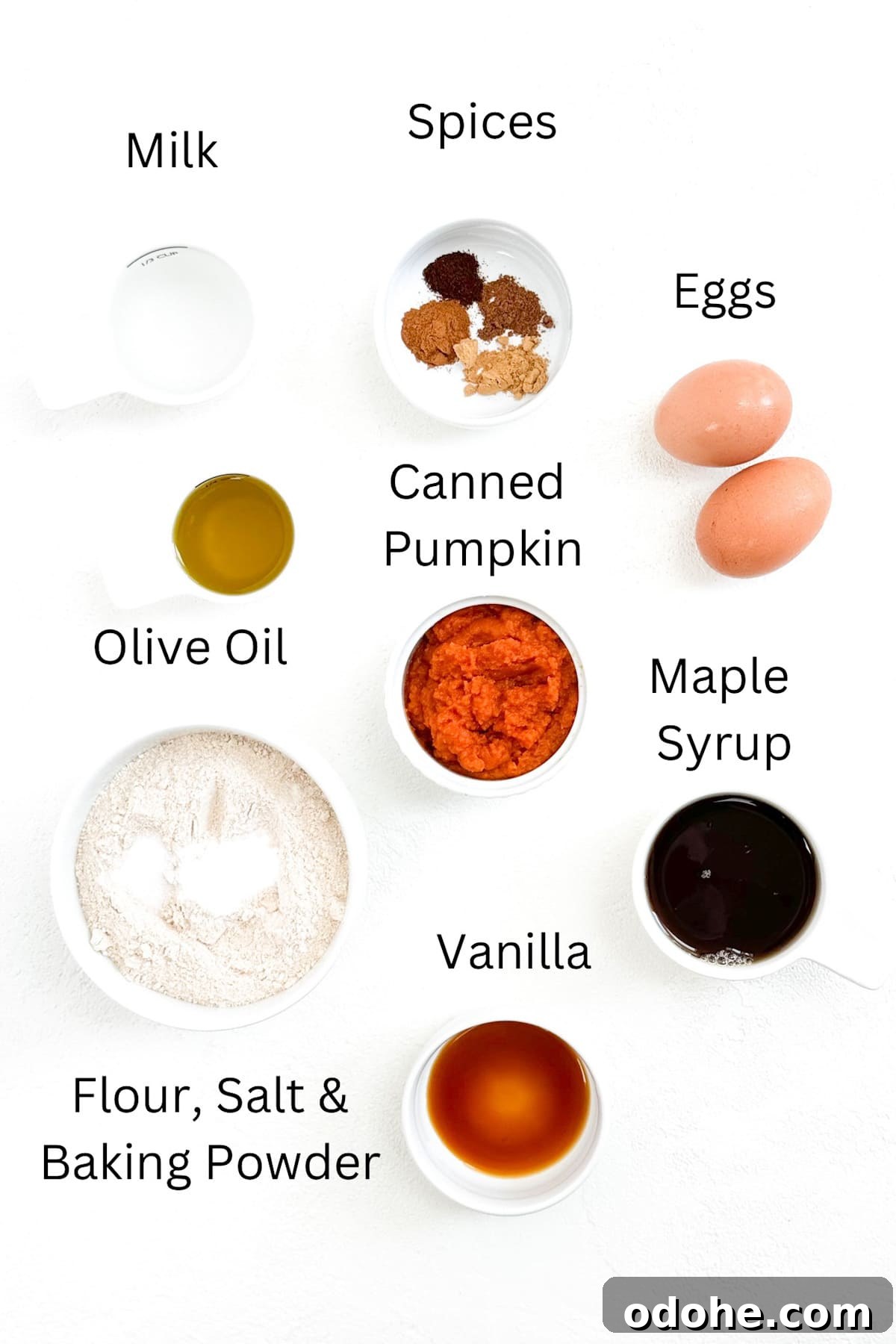 Ingredients for whole wheat pumpkin waffles labeled and placed individually on a white background.