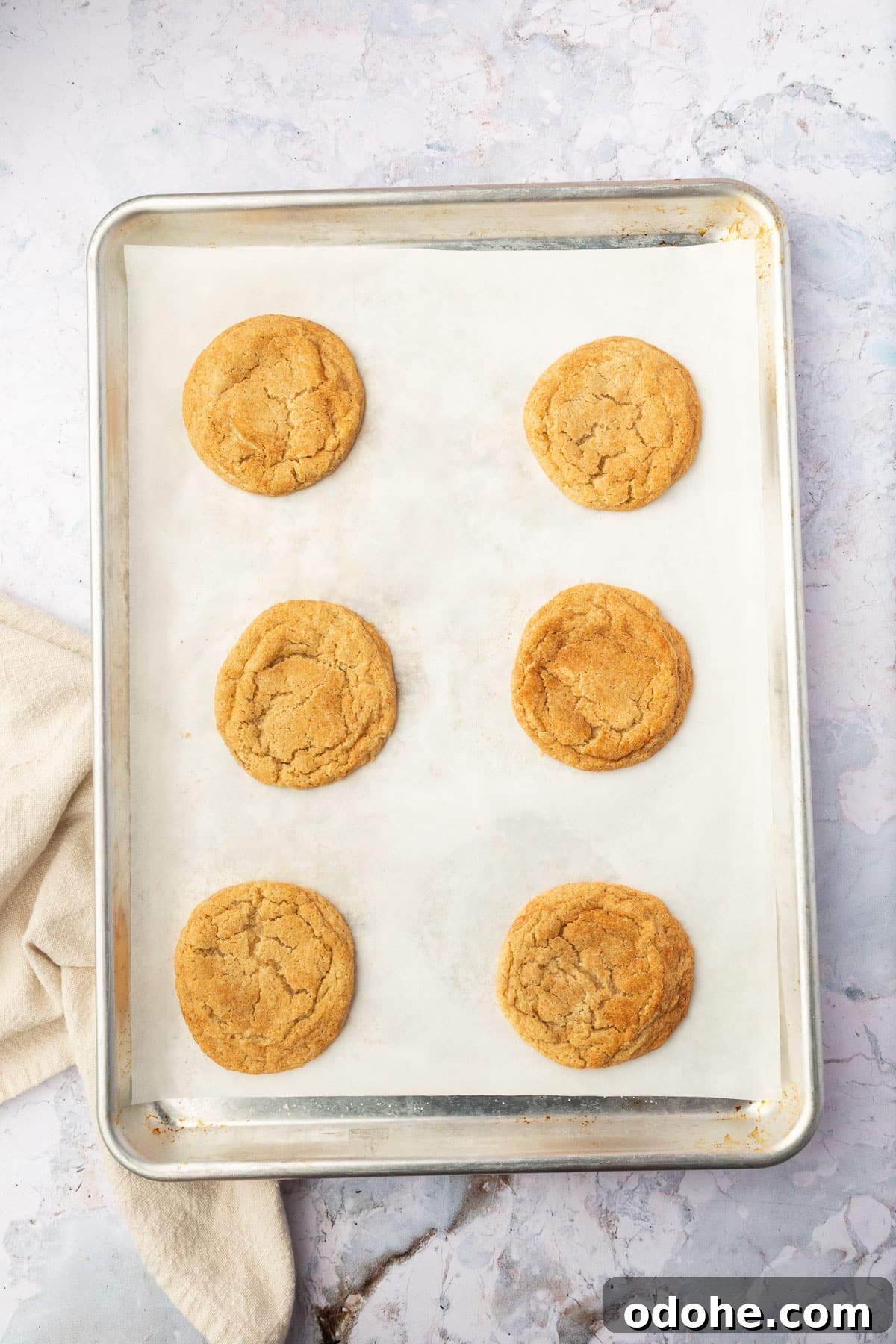 Gluten-Free Snickerdoodle Cookies Recipe: Soft, Cinnamon-Sugar Treats 12 Six snickerdoodle cookies on a sheet pan lined with parchment paper.