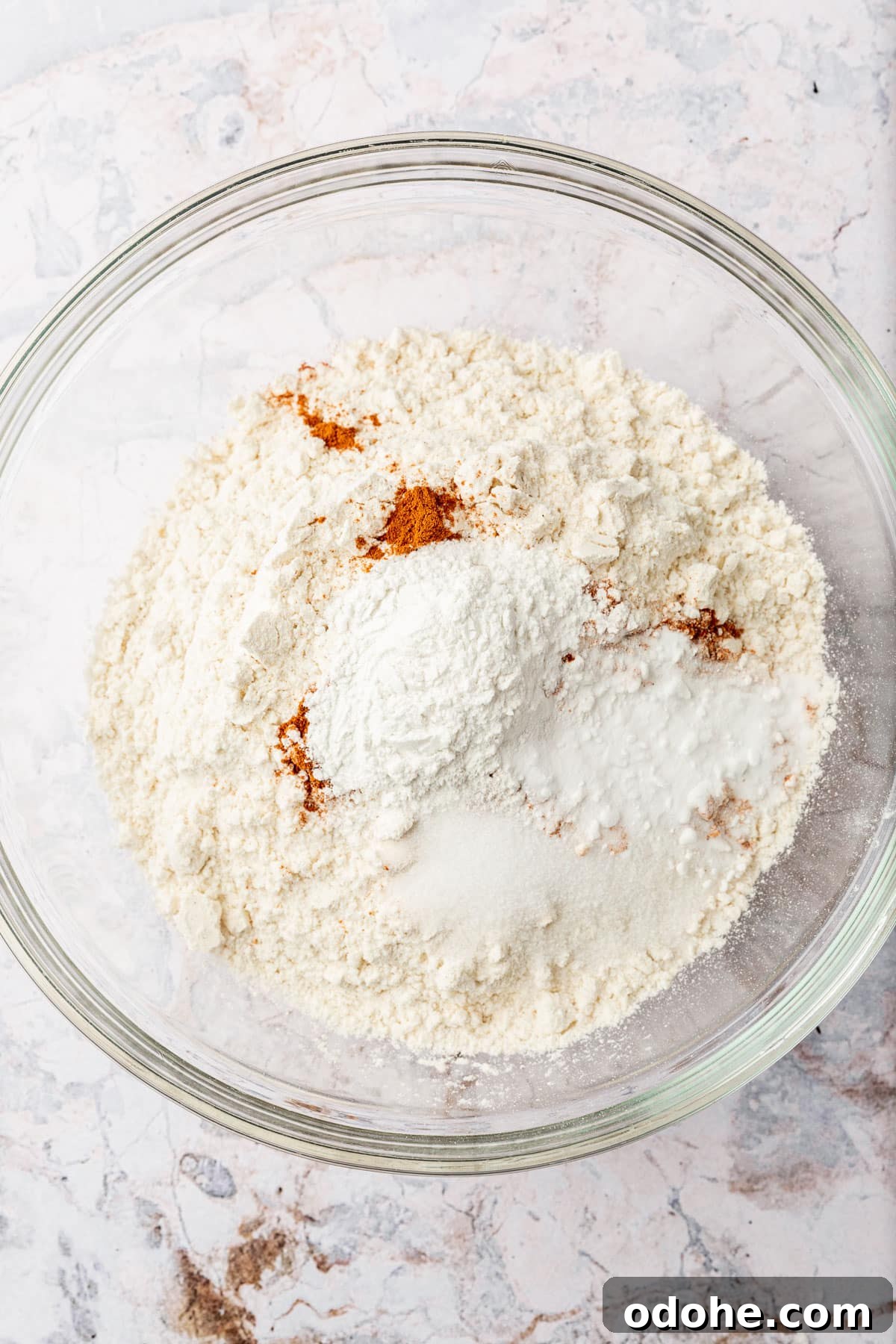 Gluten-Free Snickerdoodle Cookies Recipe: Soft, Cinnamon-Sugar Treats 4 A glass mixing bowl with gluten-free flour, cinnamon, cream of tartar, salt, and baking soda in it before whisking together.