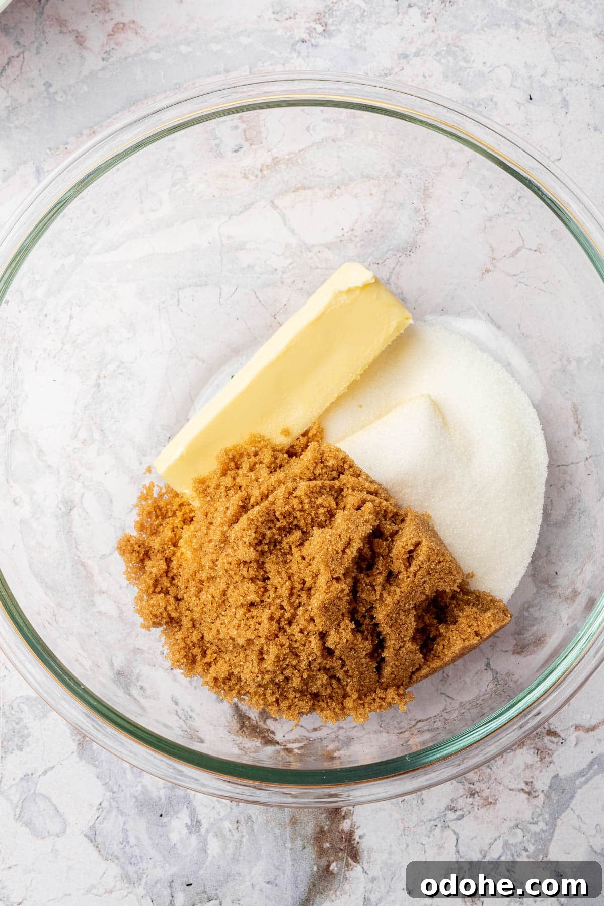 Gluten-Free Snickerdoodle Cookies Recipe: Soft, Cinnamon-Sugar Treats 5 A glass mixing bowl with a stick of butter, granulated sugar, and brown sugar in it before mixing together.