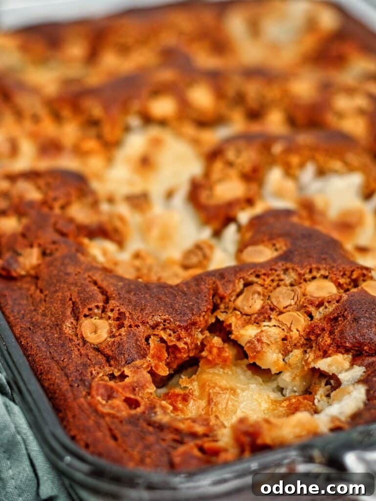 pumpin earthquake cake in glass pan up close with green towel on the left.
