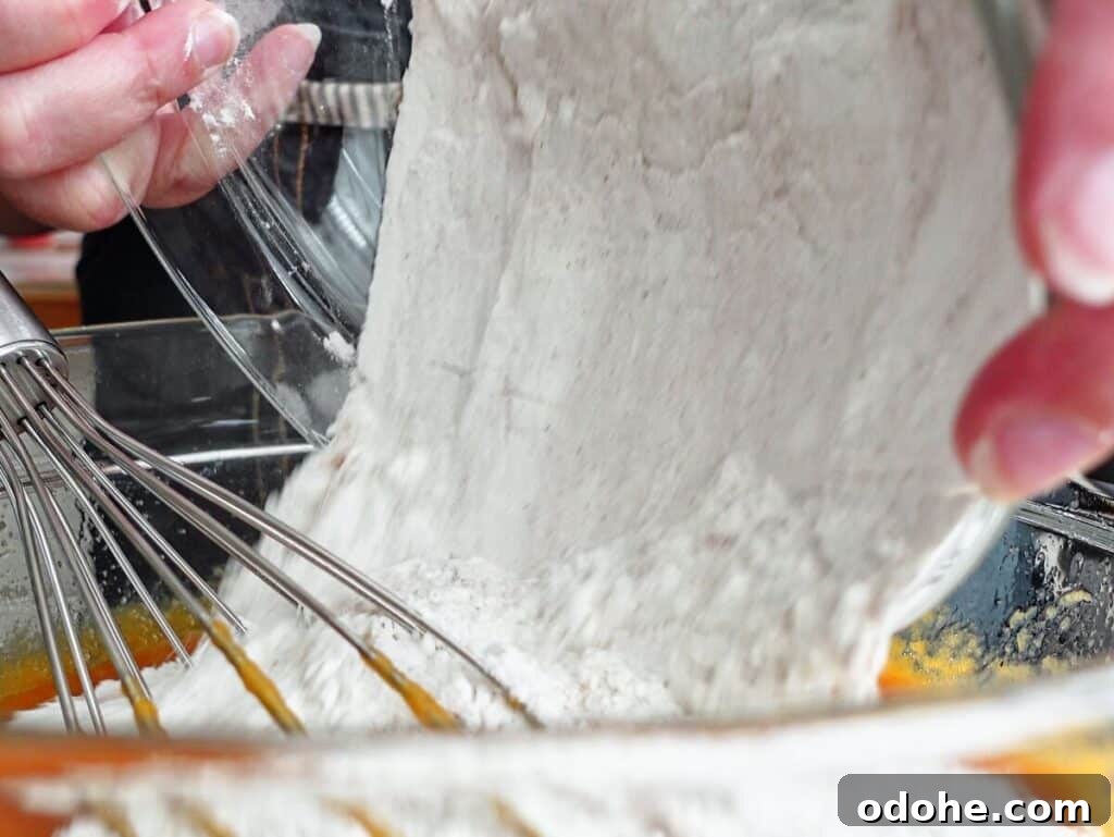 dumping dry ingredients into wet ingredients.
