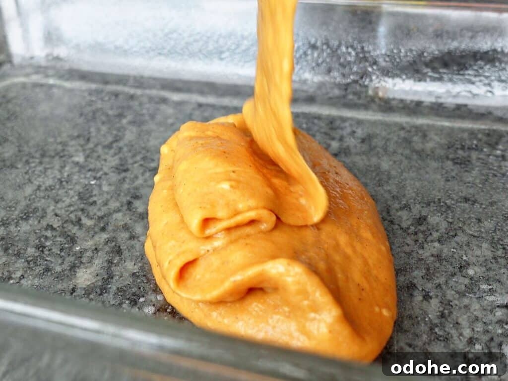 pouring cake batter into greased glass baking dish.