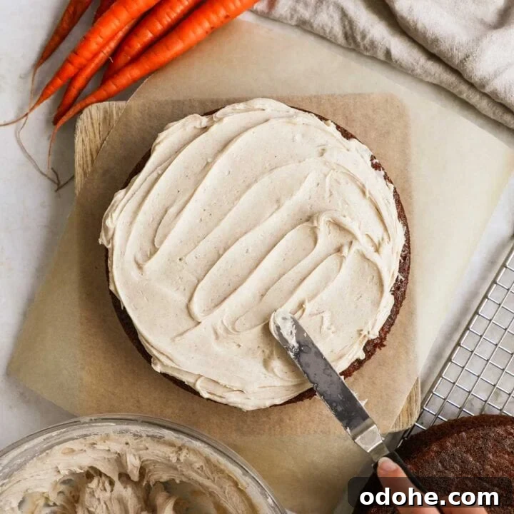 Homemade chai cream cheese frosting being spread on a carrot cake.