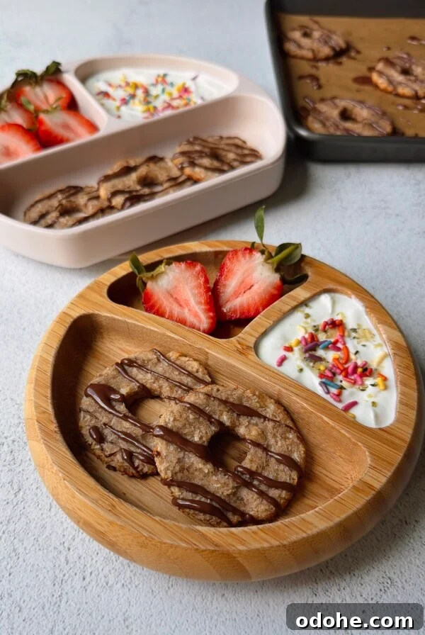 Coconut banana cookies served with yogurt and strawberries.