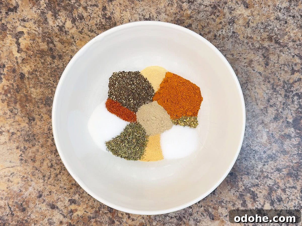 Homemade Cajun Seasoning Mix for Bold, Authentic Flavor 4 Cajun seasoning ingredients measured out in a small mixing bowl.