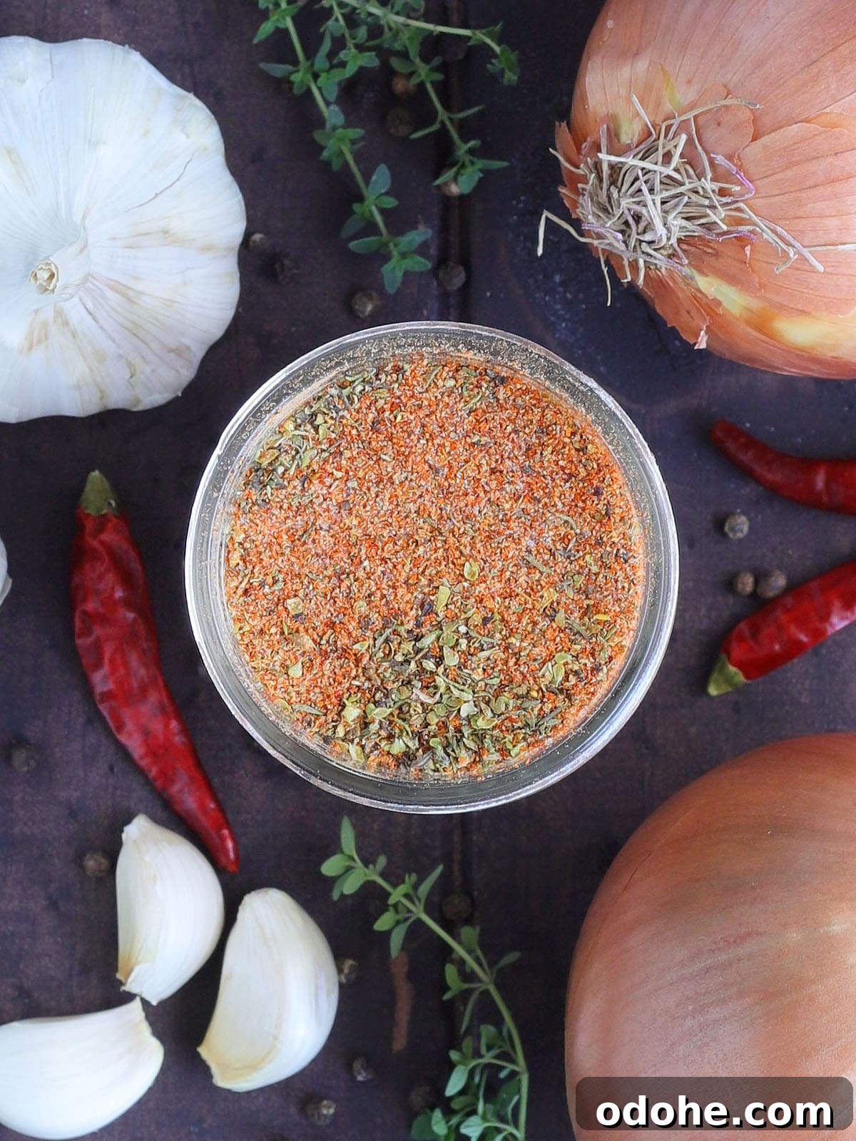 Homemade Cajun Seasoning Mix for Bold, Authentic Flavor 5 Homemade Cajun seasoning in a glass Mason jar with onions, garlic and seasonings in the background.