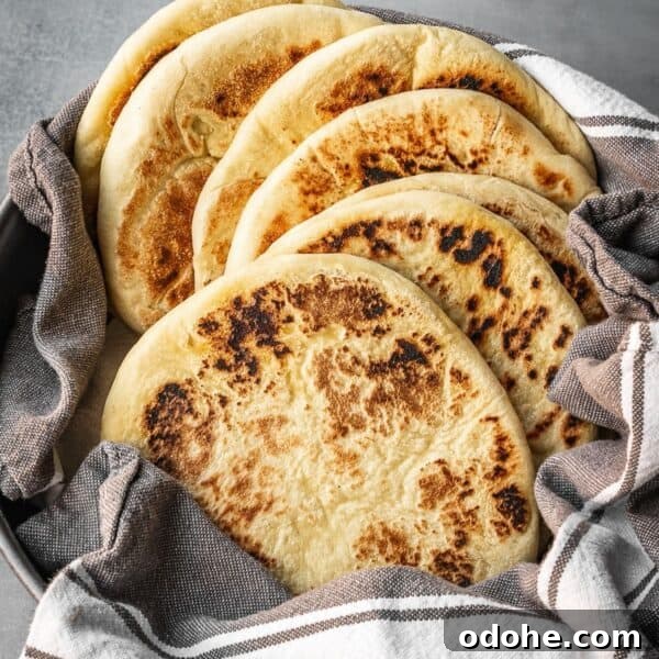 A bowl with a stack of freshly made Greek pitas.