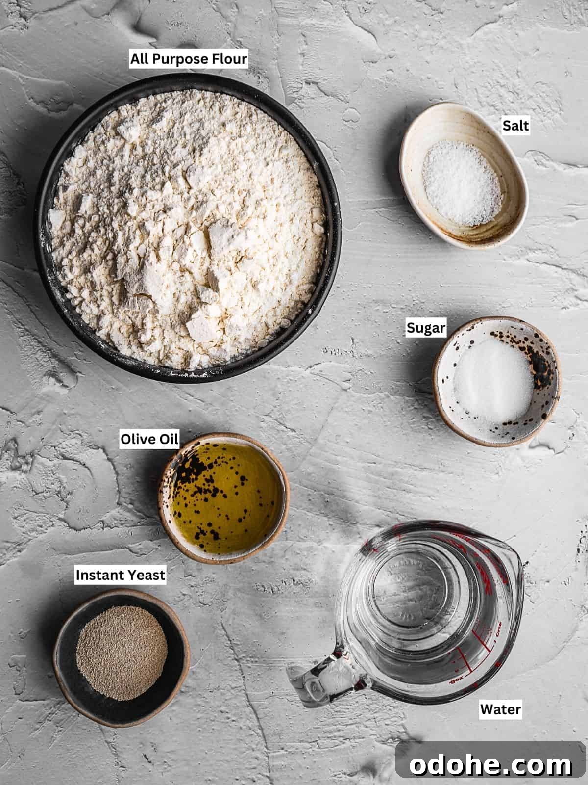 Homemade Greek pita bread recipe ingredients with individual labels on a board.