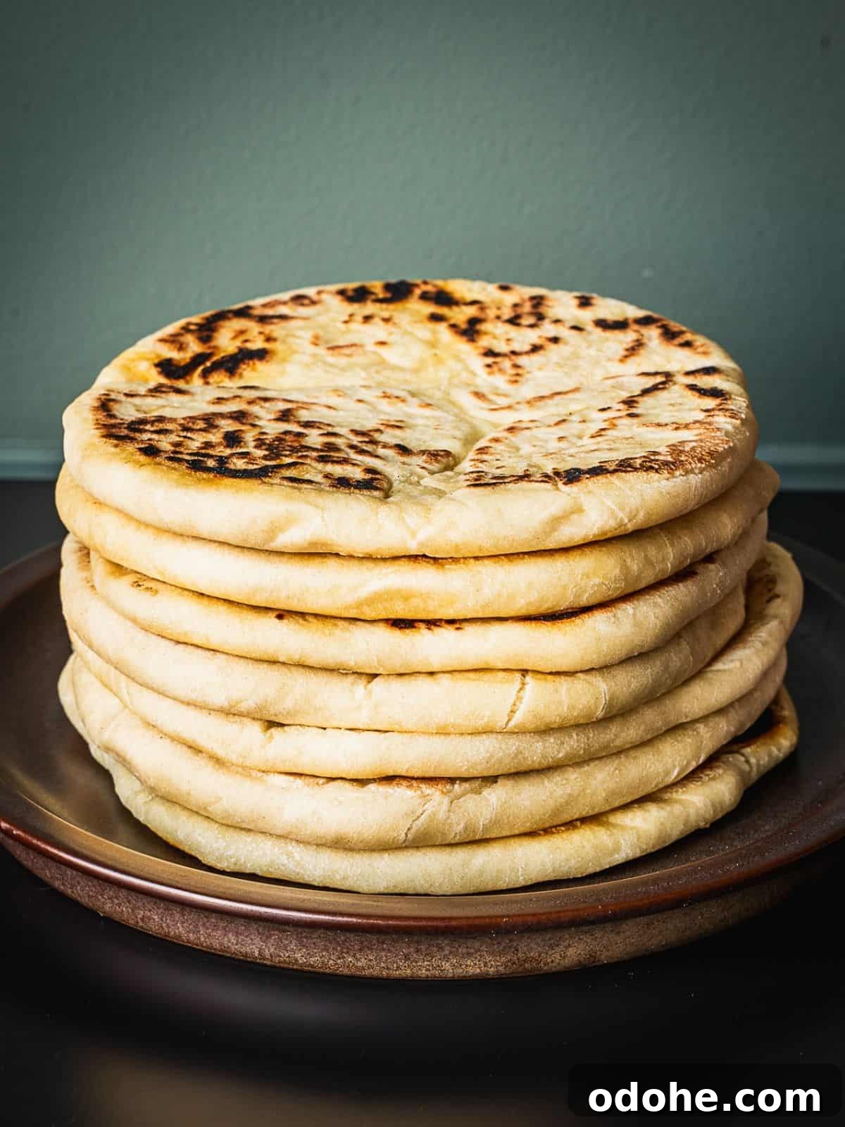 A bowl with a stack of freshly made Greek pitas.