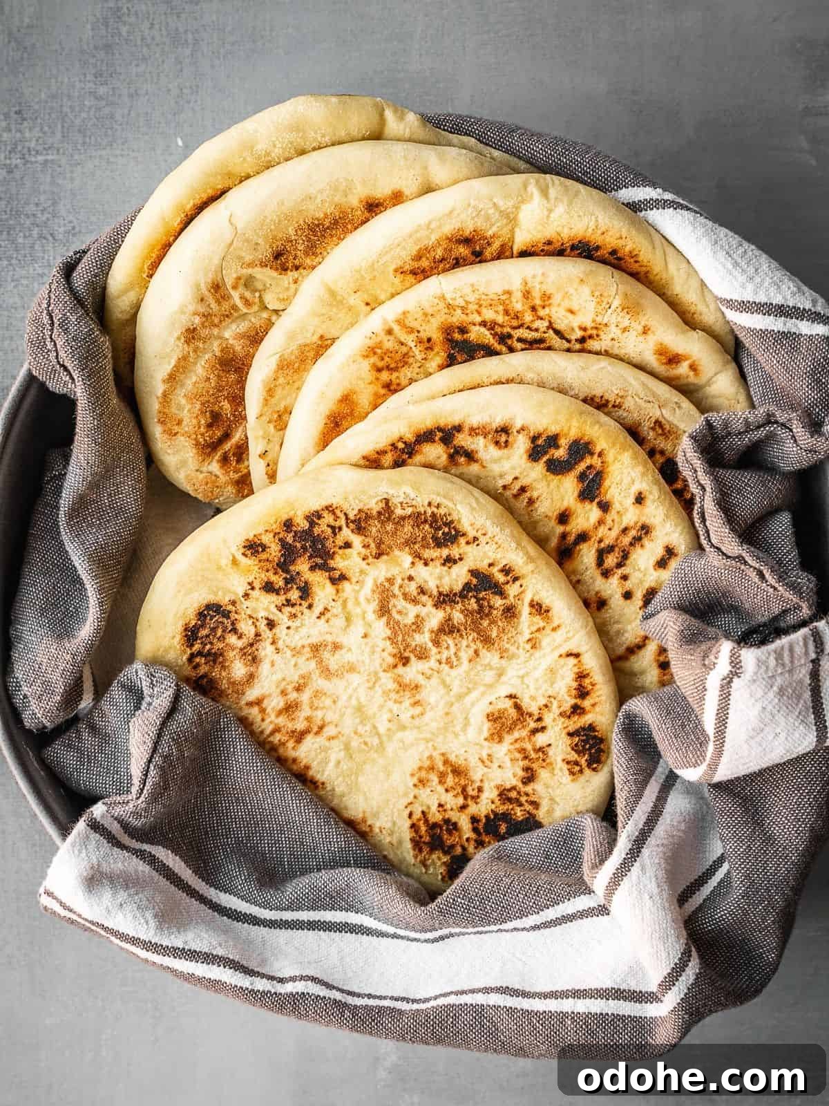 A bowl with a stack of freshly made Greek pitas.