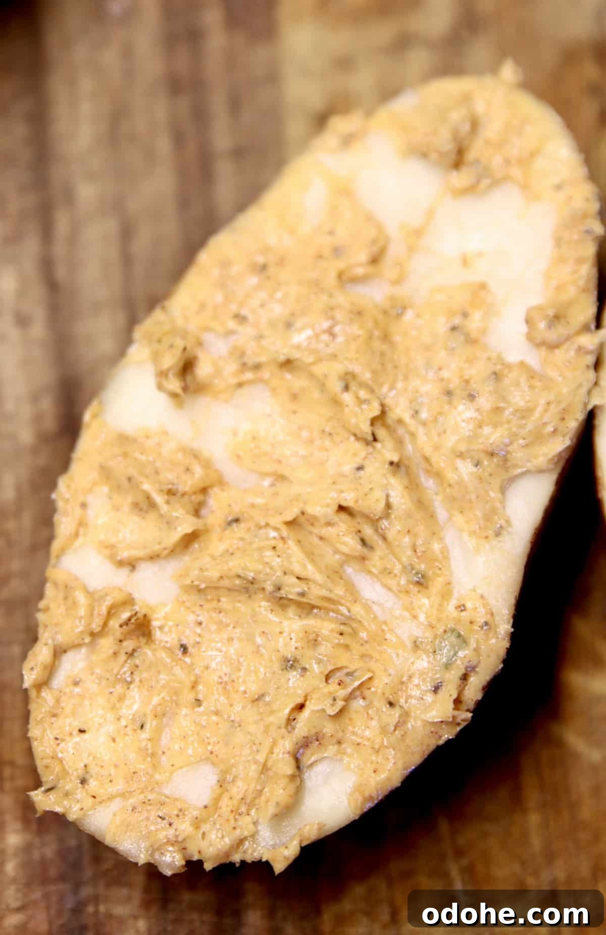 Creole butter spread onto potato half.