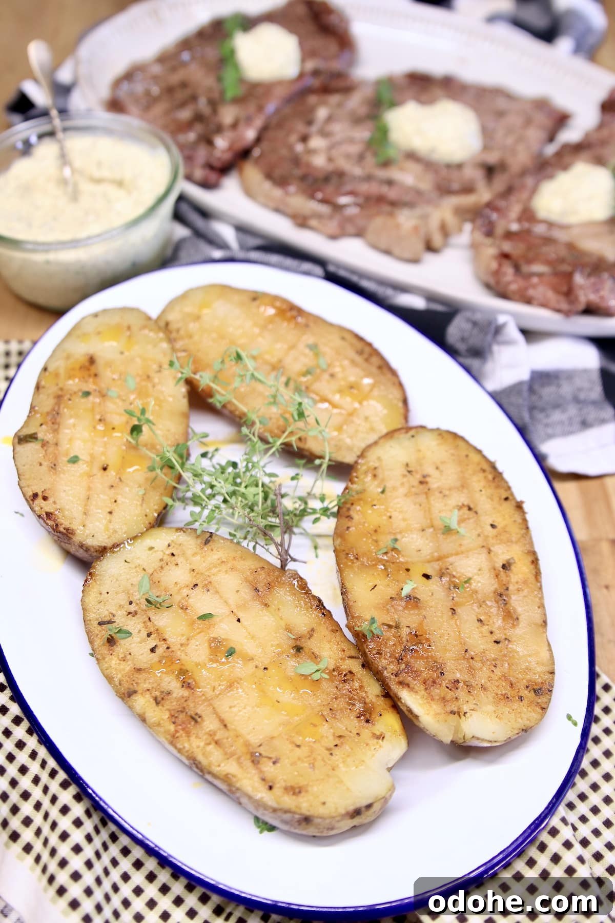 Grilled baked potatoes halves on a platter.
