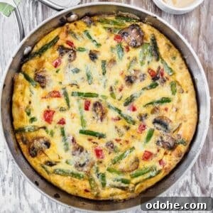 Vegetable Frittata Recipe with Fresh Herbs and Melted Cheese 5 Top view of vegetable frittata in skillet.