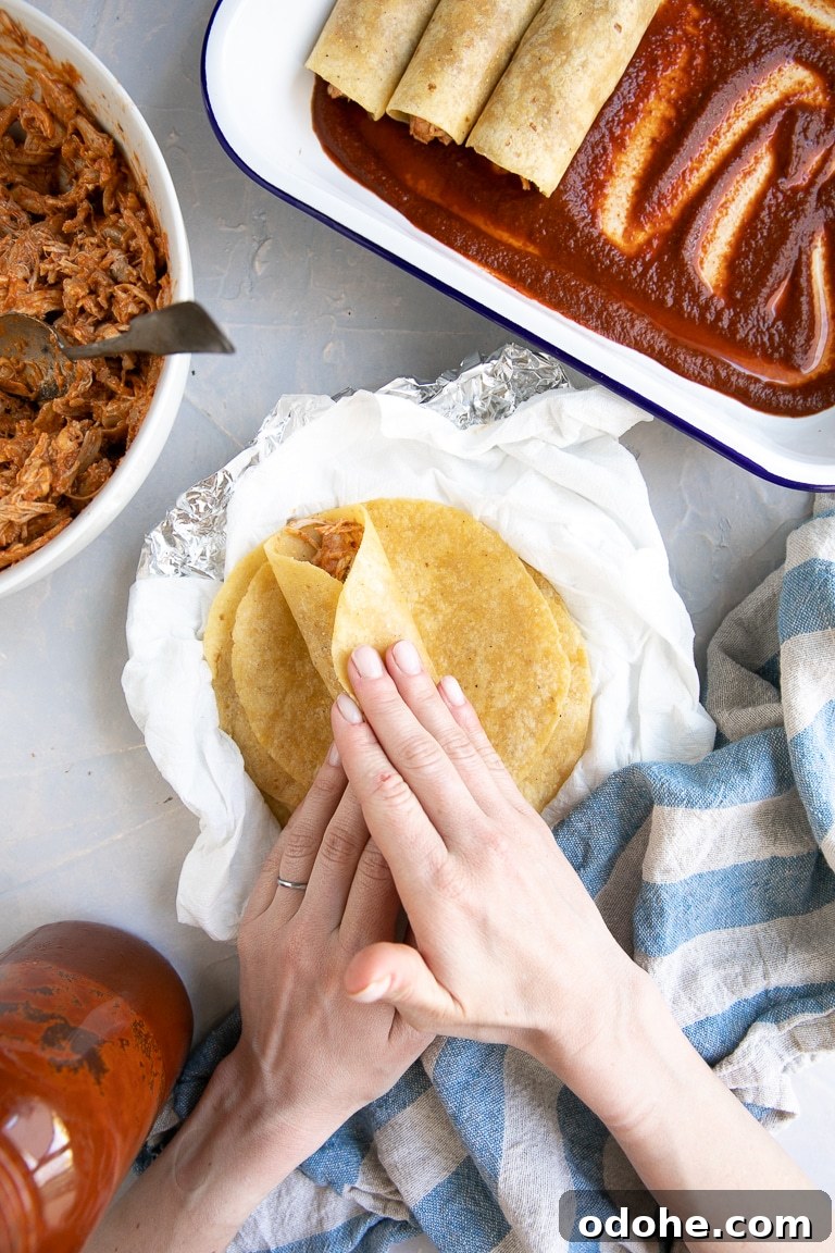 40+ Authentic Mexican Recipes for an Unforgettable Cinco de Mayo 18 Rolling a corn tortilla filled with shredded chicken.