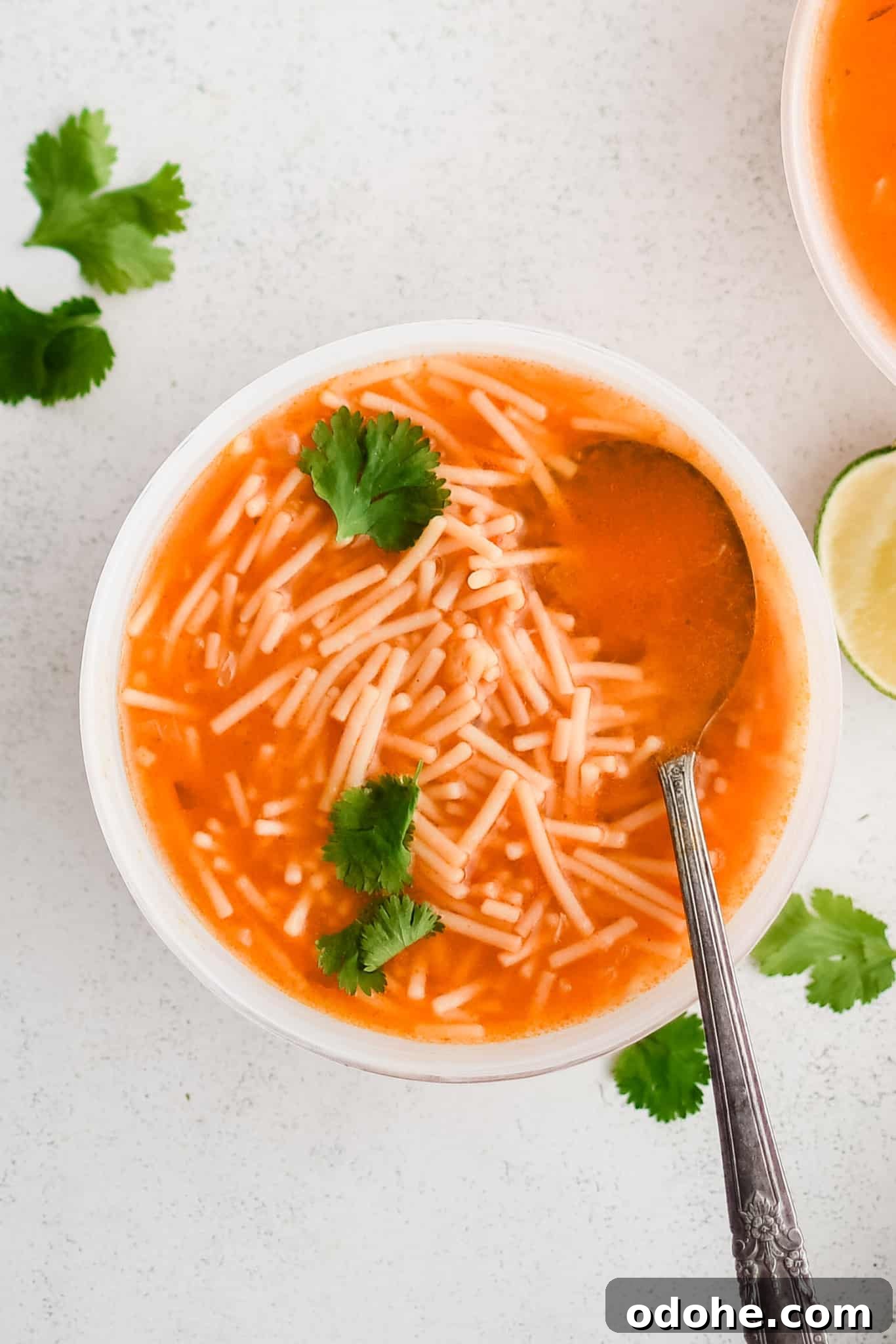 40+ Authentic Mexican Recipes for an Unforgettable Cinco de Mayo 30 White soup bowl filled with Sopa De Fideo (Mexican Noodle Soup) made with a light tomato broth and small fideo noodles.