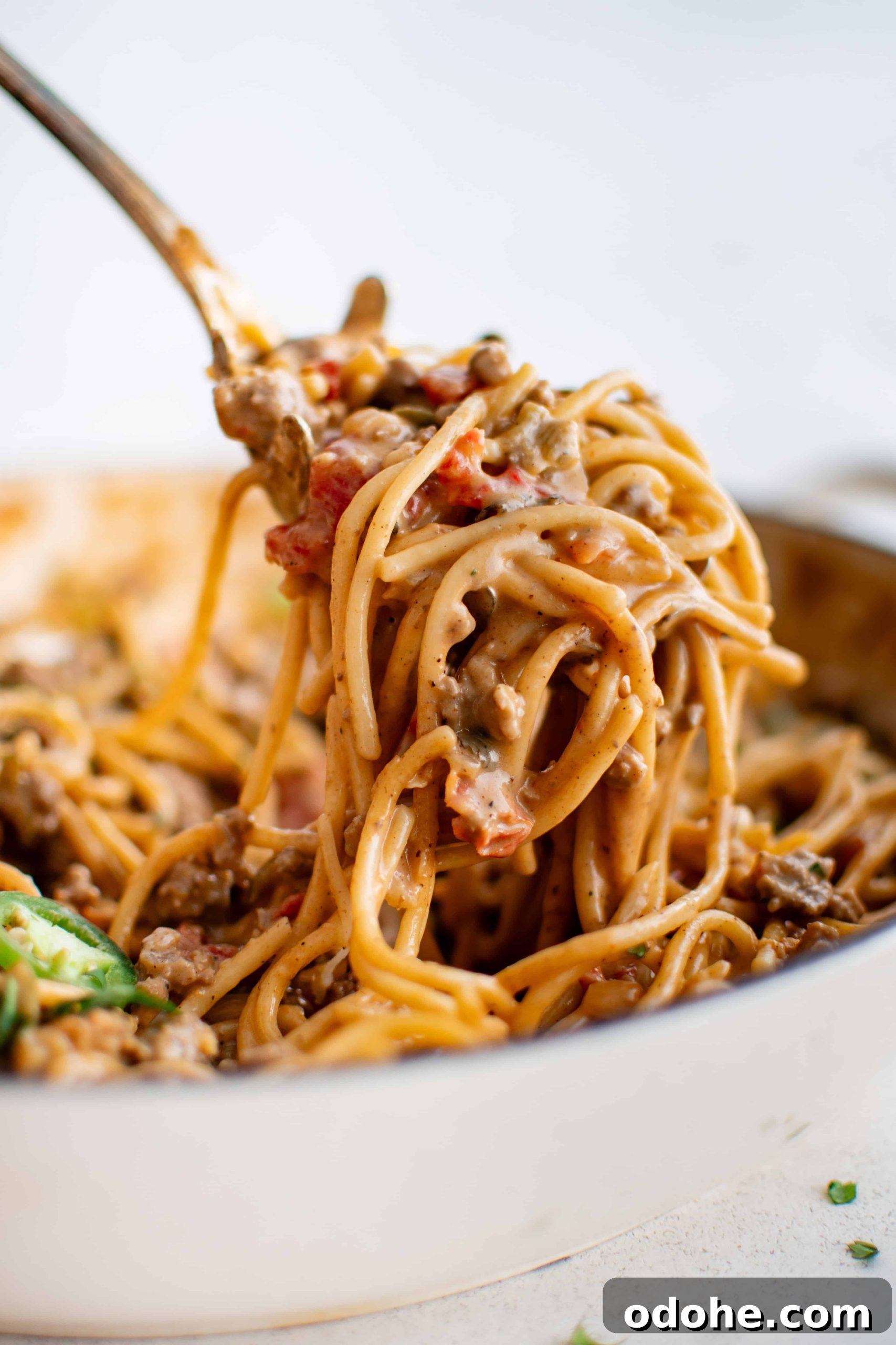40+ Authentic Mexican Recipes for an Unforgettable Cinco de Mayo 38 Large serving of taco spaghetti being removed from a large pan by a stainless steel pasta serving spoon.