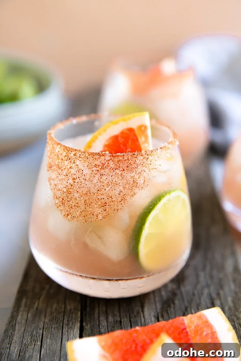 40+ Authentic Mexican Recipes for an Unforgettable Cinco de Mayo 46 Paloma cocktail served with a chili salt rim and garnished with lime and fresh grapefruit.