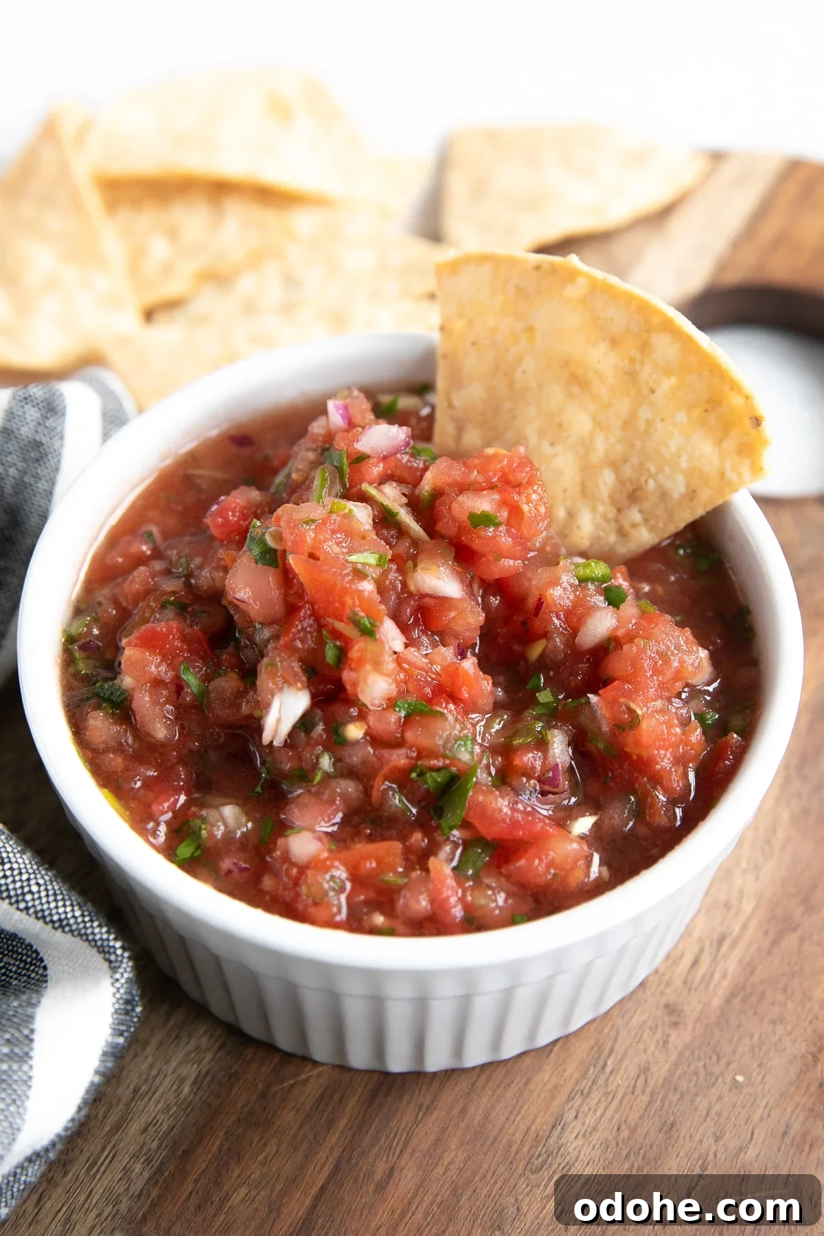 40+ Authentic Mexican Recipes for an Unforgettable Cinco de Mayo 6 Homemade salsa in a small white bowl served with tortilla chips.