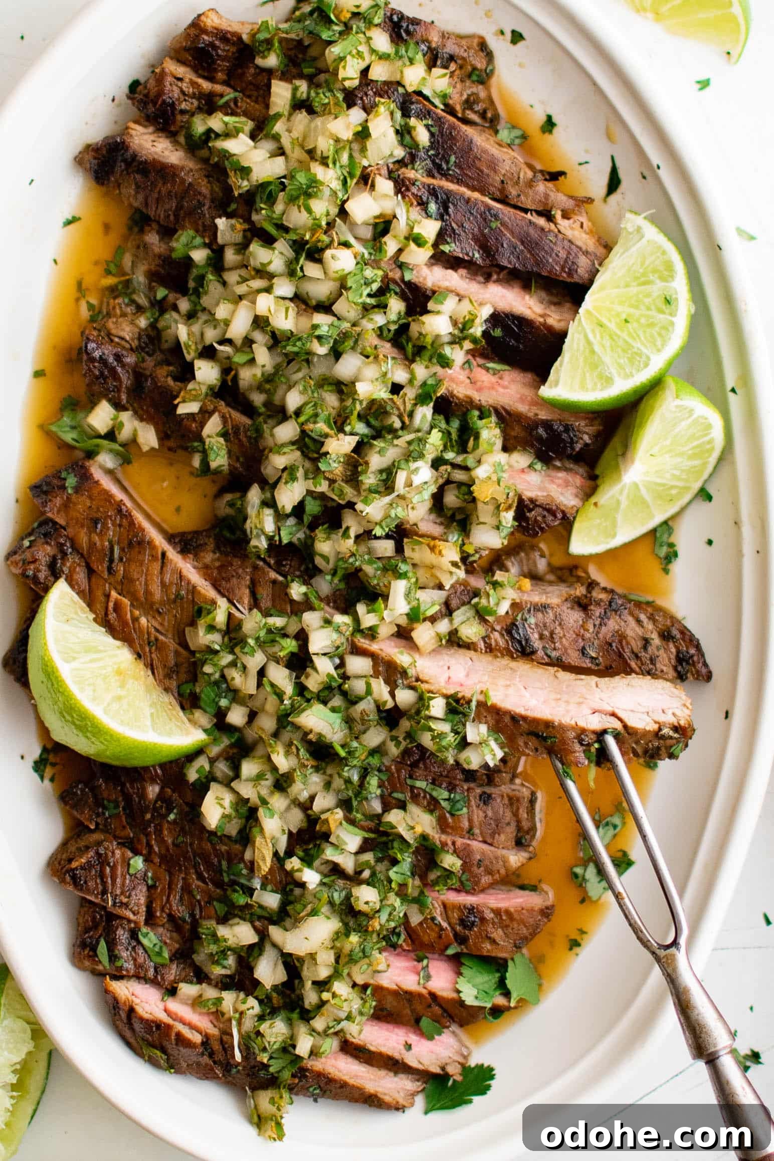 40+ Authentic Mexican Recipes for an Unforgettable Cinco de Mayo 7 Large white platter filled with thinly sliced carne asada that's been topped with homemade salsa.