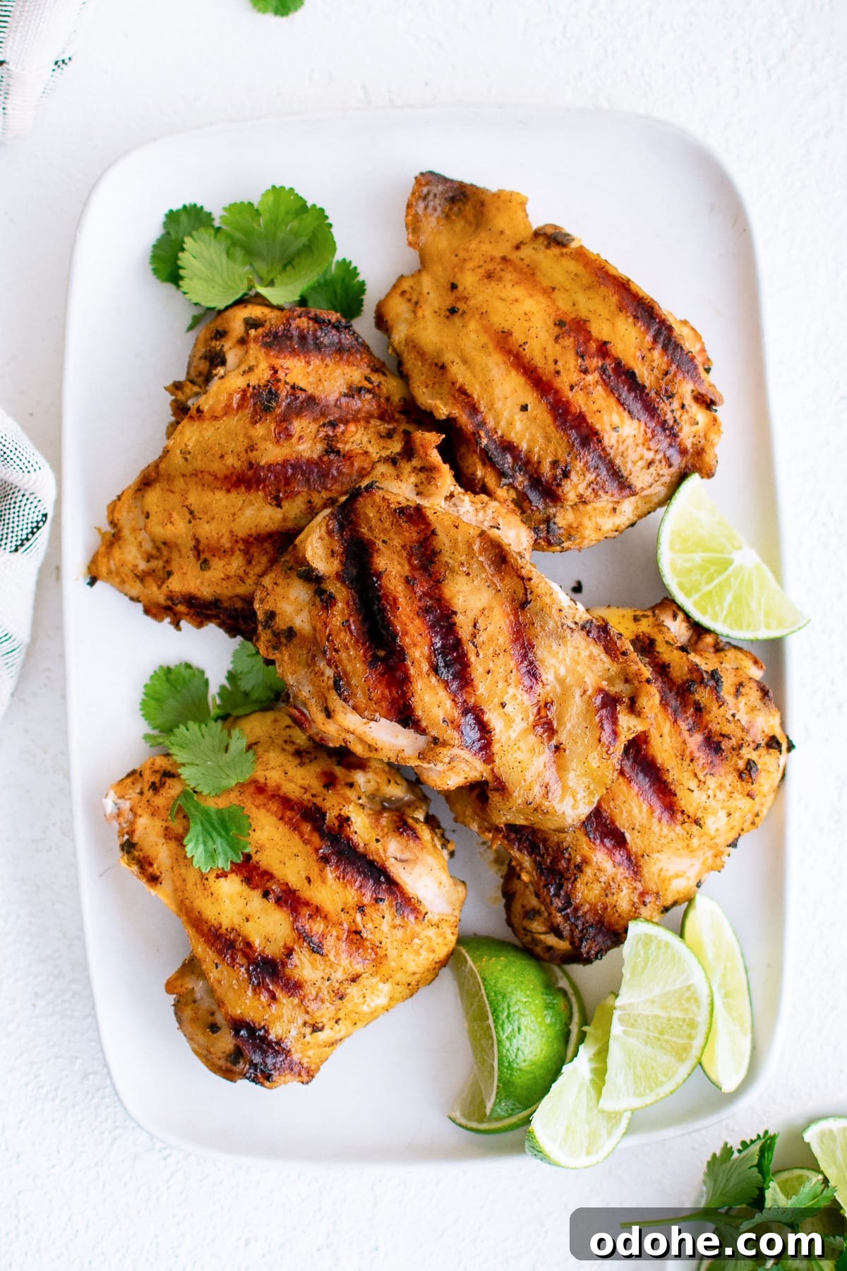 40+ Authentic Mexican Recipes for an Unforgettable Cinco de Mayo 8 White plate filled with grilled pollo asado served with a side of lime slices.