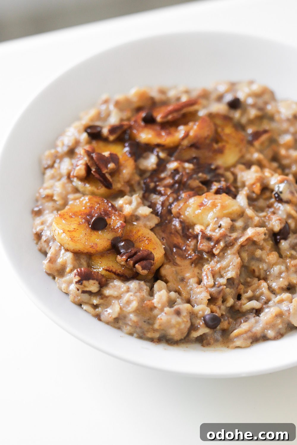 a bowl of banana bread stovetop oatmeal topped with chocolate chips and caramelized bananas