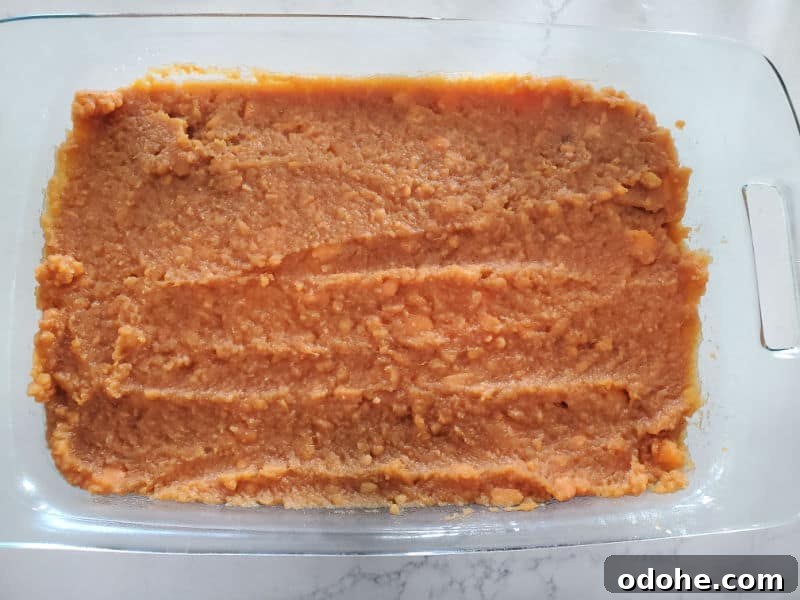 mashed sweet potatoes spread in a glass casserole dish