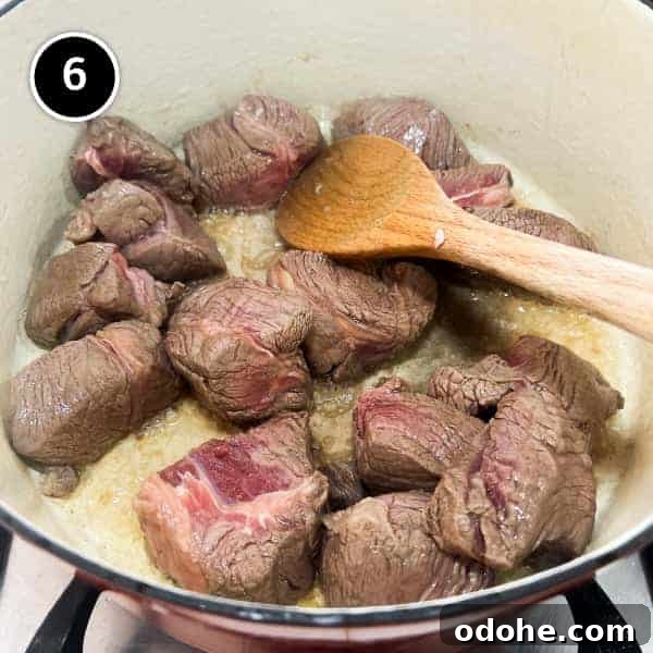 Thai Beef Massaman Curry | cookeatworld.com Chunks of beef frying in a pan.