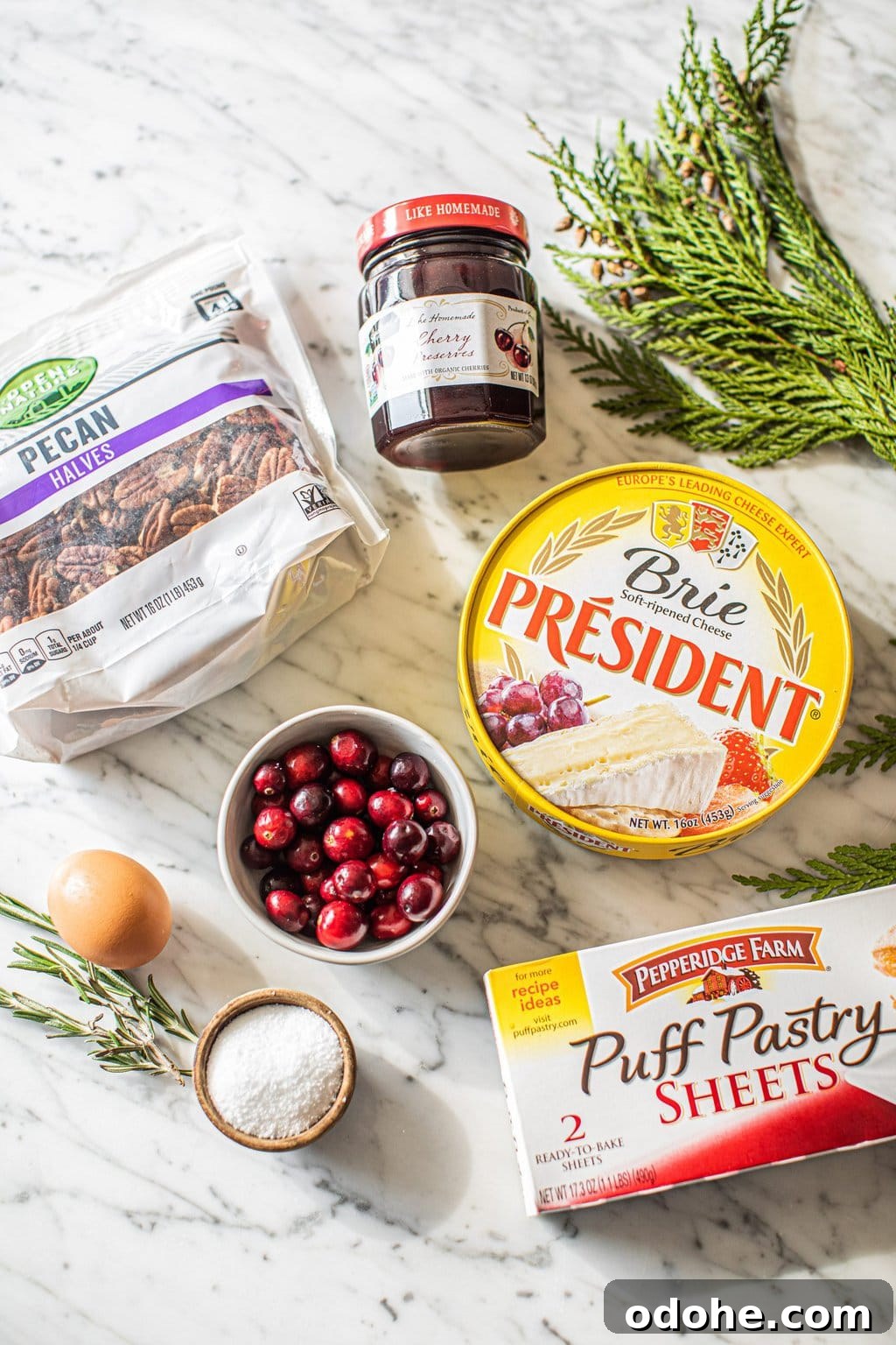 Warm Baked Brie with Cherry-Pecan Topping 3 pecans, egg, cranberries, salt, cherry preserves, brie, rosemary, puff pastry