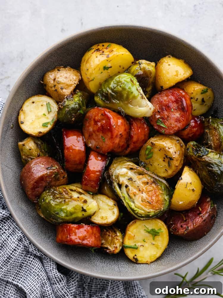 Sheet Pan Sausage and Veggies Sausage, Brussels sprouts and potatoes in a gray bowl