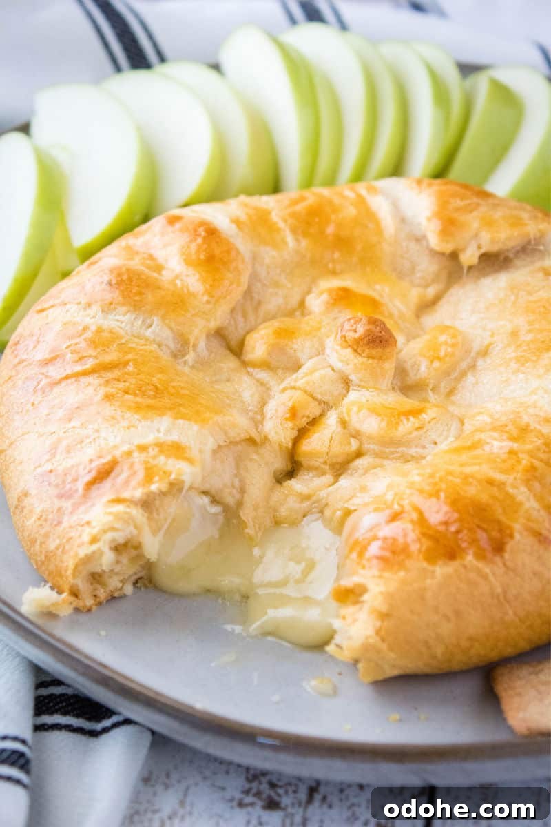 crescent roll baked brie cut open with cheese oozing out