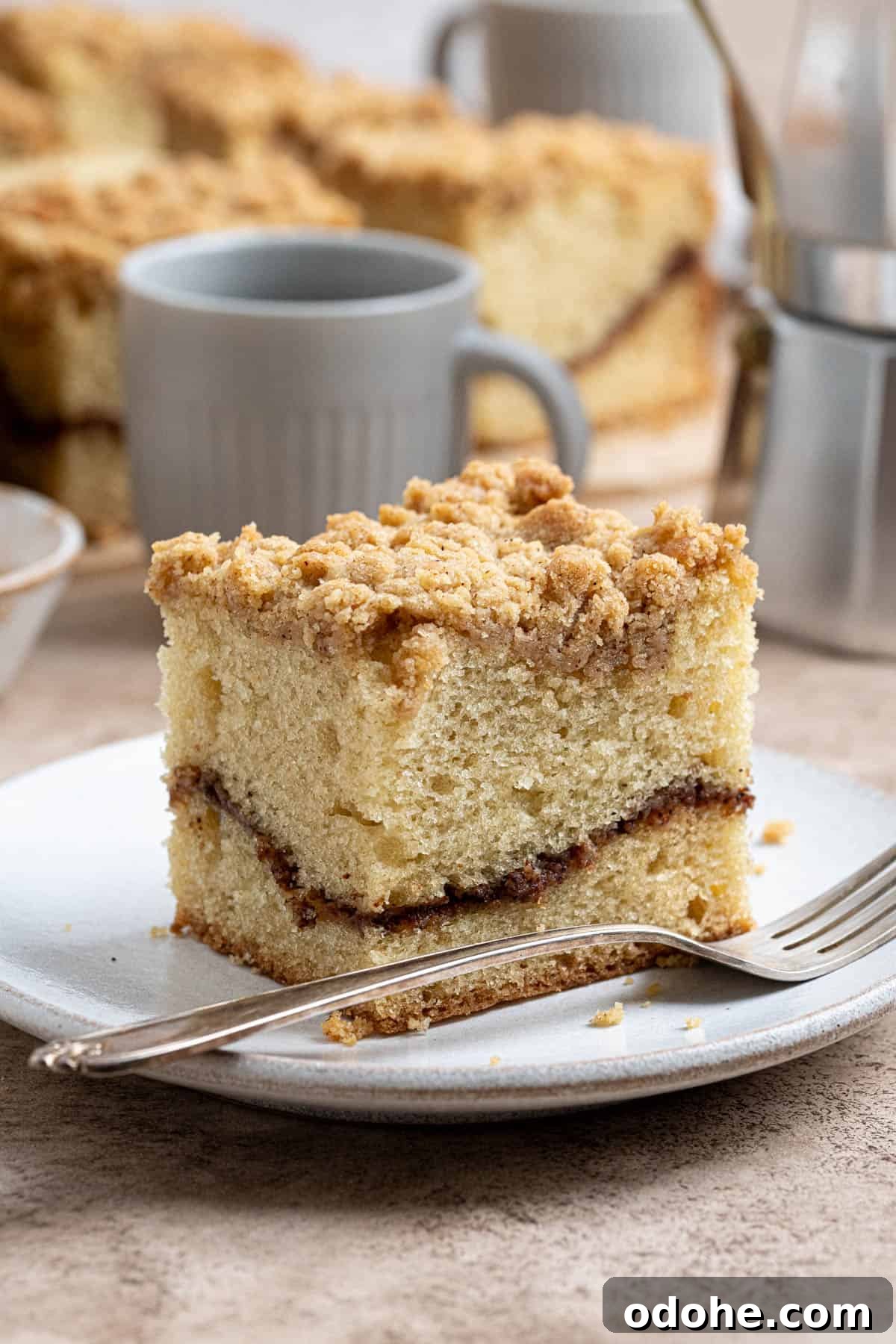 A slice of vegan coffee cake on a plate with a fork.