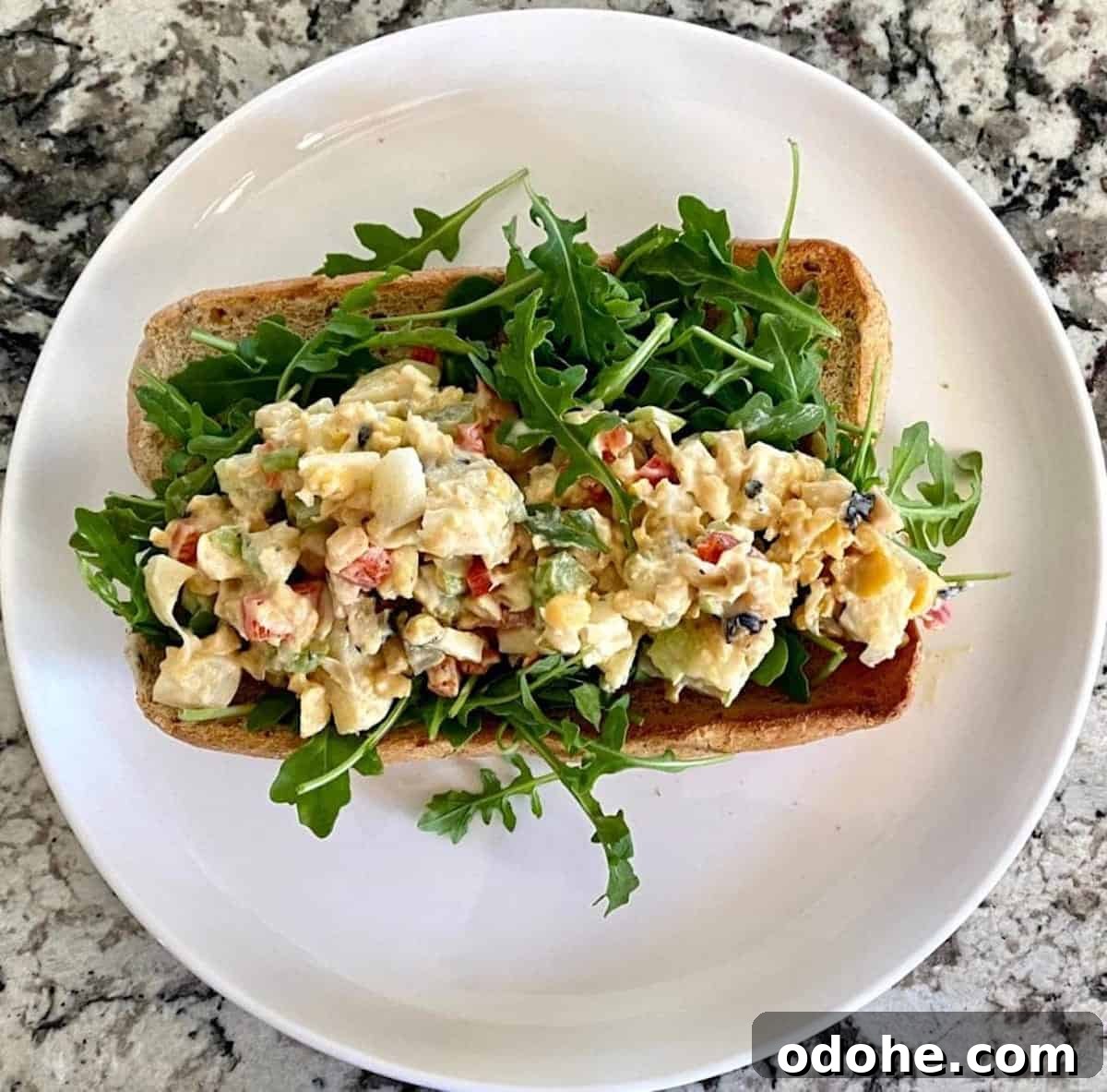 Hearts of Palm Vegan Lobster Roll Recipe 8 Lobster salad in a roll with arugula on a plate.