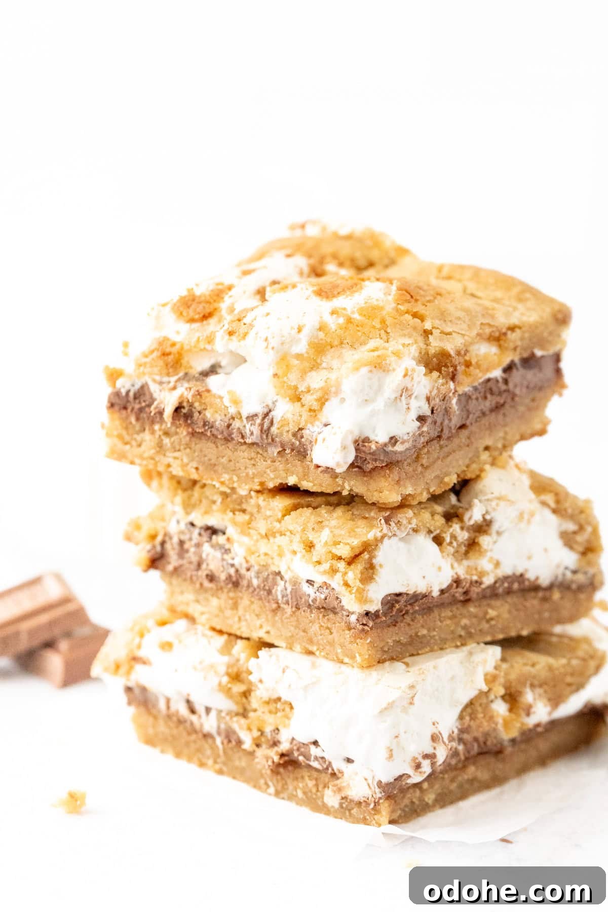 Chewy S'mores Cookie Bars 6 Stack of three s'mores cookie bars with chocolate and marshmallow cream in the middle