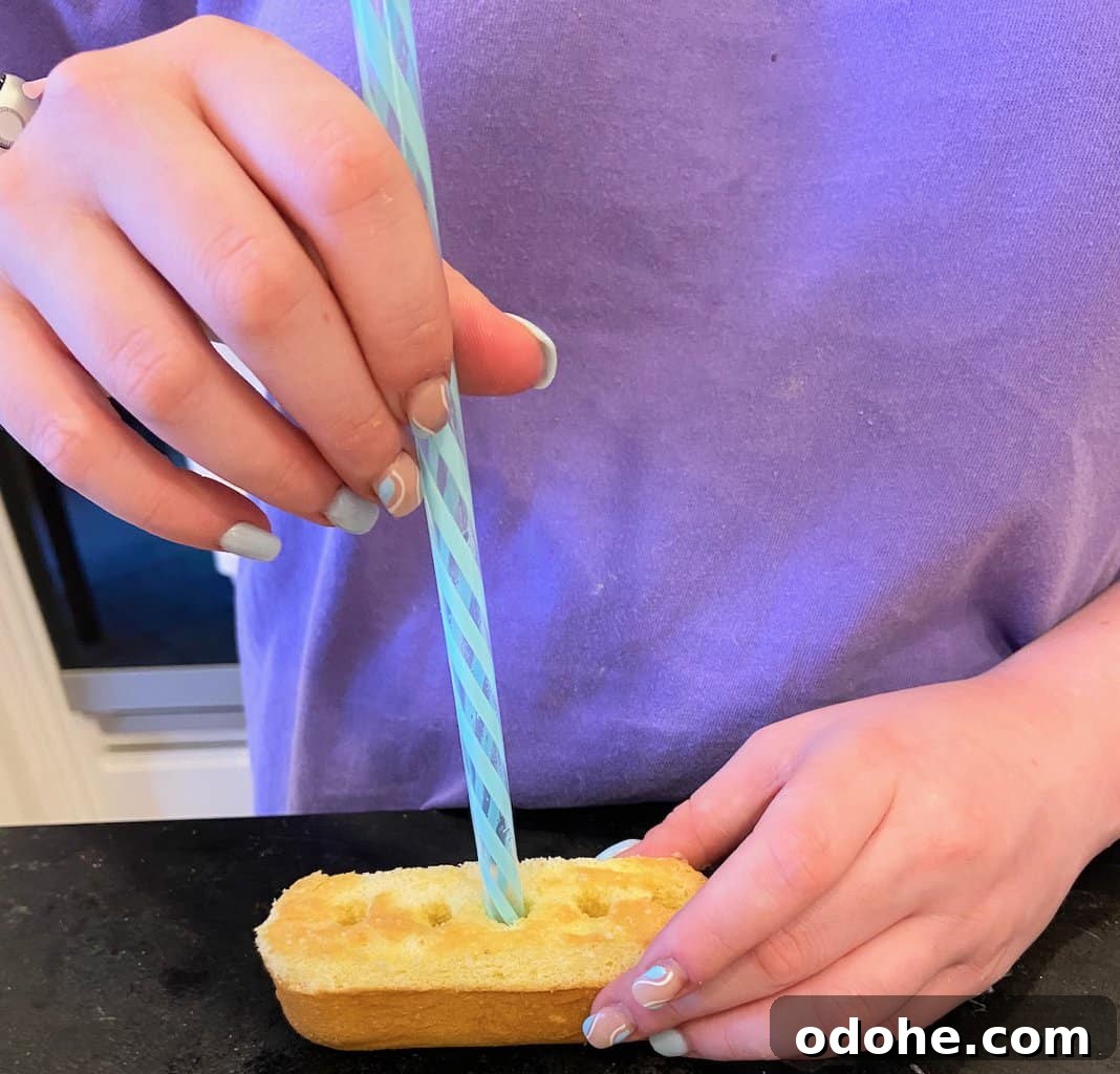 Homemade Lemon Raspberry Twinkies Recipe 6 Model demonstrating how to poke holes in the bottom of the twinkie.