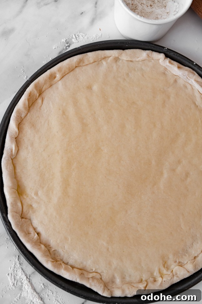 Photo of a homemade pizza dough on a baking dish