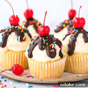 Ice Cream Cupcakes Recipe: Creamy No-Bake Dessert Cups 9 Vanilla ice cream cupcakes topped with white frosting, chocolate drizzle, rainbow sprinkles, and a red cherry on top