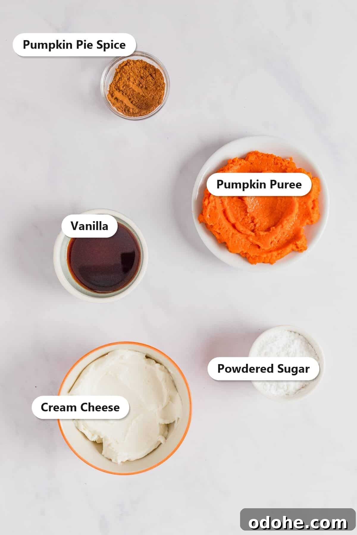 Ingredients to make pumpkin dip including pumpkin puree, cream cheese, powdered sugar, pumpkin pie spice, and vanilla.