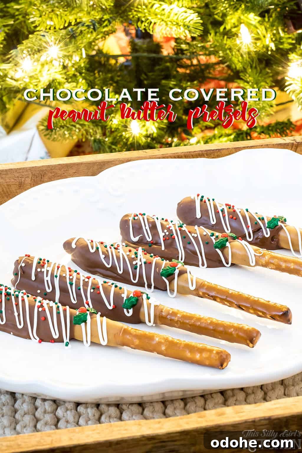 Chocolate covered peanut butter pretzels with white chocolate drizzle and sprinkles standing in a jar.